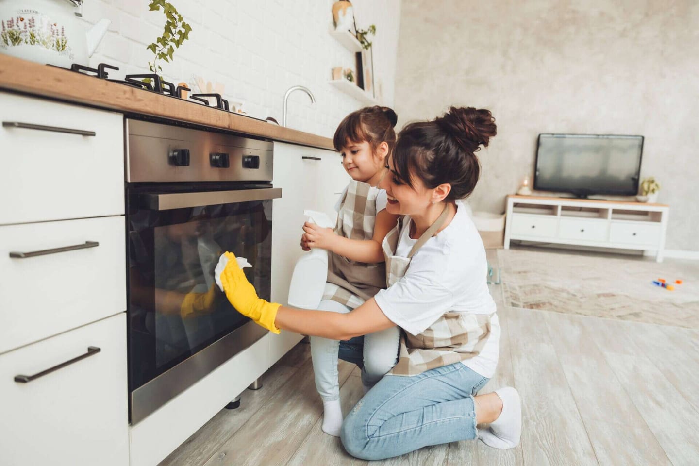 A little girl and her mum cleaning the kitchen together