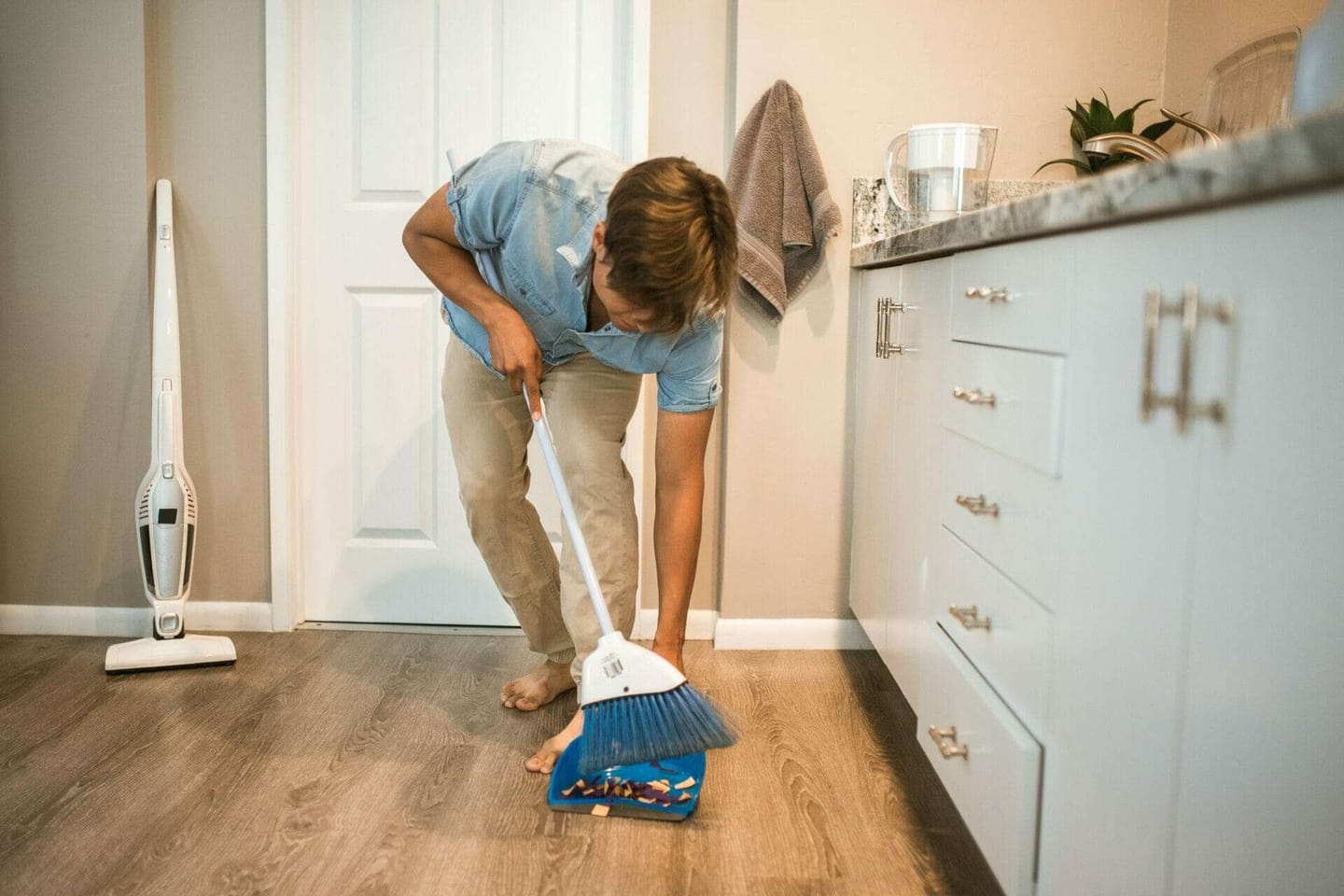 Man sweeping the floor - How to keep my kitchen clean.